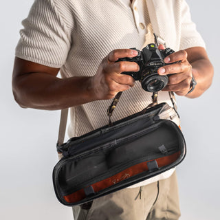 NOMATIC Luma Camera Sling 9L, close-up of model holding a camera with the bag open for quick access