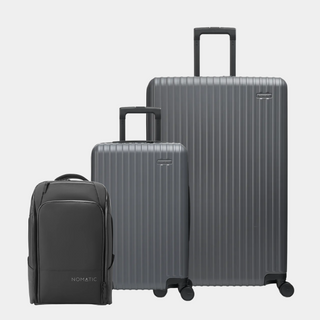 Set of gray suitcases and a black backpack on a light gray background#color_gray