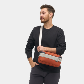 NOMATIC Luma Camera Sling 9L in rust, worn cross-body by model, front view